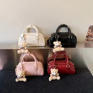 Sac à main Boston tendance en quatre couleurs avec charm ourson et détails métalliques