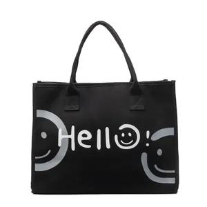 Minimalist black canvas tote bag with Hello and smiley face print for daily commute