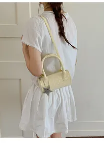 Detail of yellow polka dot cylinder bag with star charm and a shoulder strap