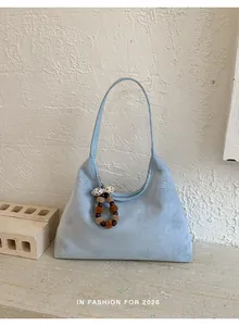 Dettaglio della borsa a spalla in pelle scamosciata azzurra con strass a stella e perline