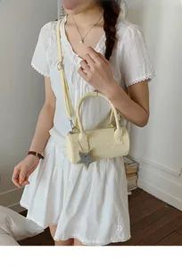 Detailed close-up of a yellow polka dot Boston bag with star charm and shoulder strap