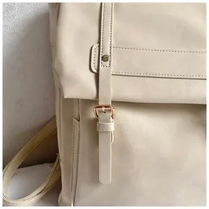 Dettaglio ravvicinato dello zaino in pelle PU crema con fibbia in oro rosa e cuciture