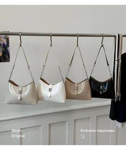 Detail of four stylish half-moon armpit bags in beige, white, khaki, and black colors