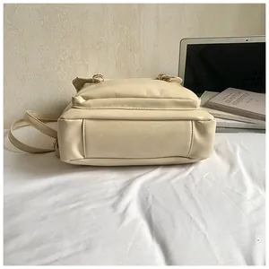 Dettaglio laterale dello zaino in ecopelle beige con fibbie dorate e cuciture precise