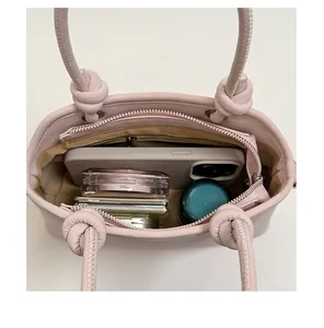 Top view of pink crossbody bag showing spacious interior with phone and cosmetics