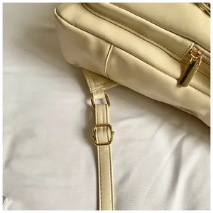 Dettaglio dello zaino in pelle PU crema con zip dorata e fibbia in metallo regolabile