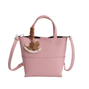 Pink lychee texture crossbody bucket bag with horse charm on white background