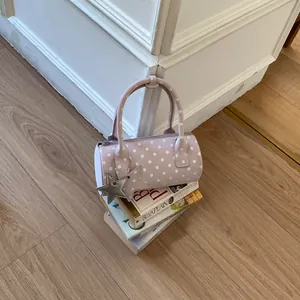 Pink polka dot barrel handbag with star charms and zipper closure for women