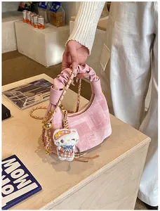 Detail of pink dumpling bag with pleated handle, gold chain and geometric woven texture