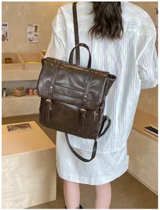Dettaglio dello zaino retrò in pelle marrone scuro con fibbie metalliche in un caffè