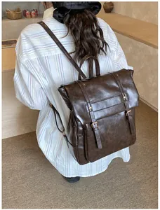 Dettaglio dello zaino vintage marrone scuro con texture opaca e fibbie metalliche