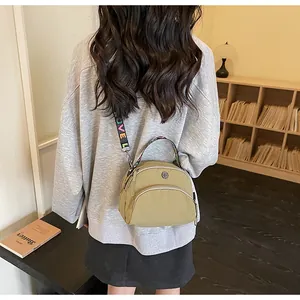 Bolso bandolera de nailon caqui con cremalleras multicapa y correa ancha estampada