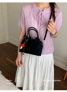 Chic black matte leather crossbody bag with mushroom charm and MUT IING embossed logo