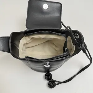 Chic black leather bucket bag interior view with drawstring closure and fabric lining