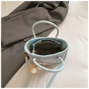 Top view of blue handbag showing striped lining, inner zipper, and sheep keychain charm