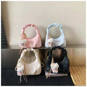 Detail view of denim dumpling bags in four colors with ruffled handles and cat charms
