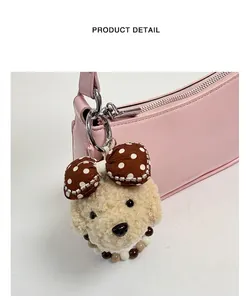 Close-up of plush puppy charm with polka dot bow and beaded detail on pink bag