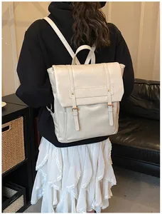 Dettaglio dello zaino vintage in pelle bianco sporco con fibbie doppie e patta di chiusura