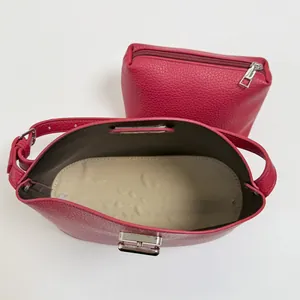 Fuchsia lychee leather bucket bag and pouch set with silver hardware shown from top view