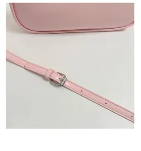 Detail of adjustable pink shoulder strap with silver buckle and embossed logo