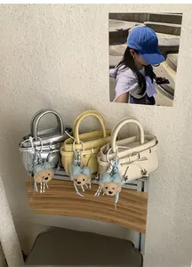 Detailed view of mini square handbags in silver and pastel colors with bear charms