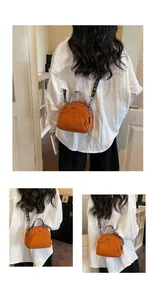 Detalle de bolso bandolera de nailon naranja con cremalleras y correa con estampado