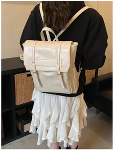 Dettaglio di uno zaino in pelle PU bianco crema con patta retrò e fibbie su un modello