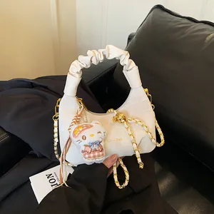 White crescent dumpling bag with pleated handle, gold chain, and a cat plush charm