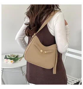 Fashionable khaki hobo bucket bag styled with a minimalist outfit and tulip decor