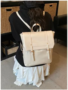 Dettaglio dello zaino in pelle bianco crema con chiusura a patta e fibbie in metallo