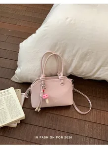 Detail of light pink shoulder bag with MUTING logo and cute mushroom plush charm