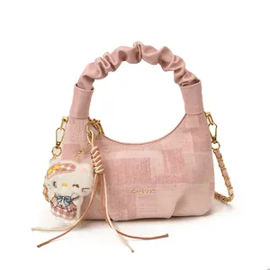 Pink jacquard crescent bag with gold chain strap and plush mascot accessory