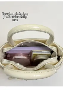 Interior view of cream white bow handbag showing storage space for phone and makeup