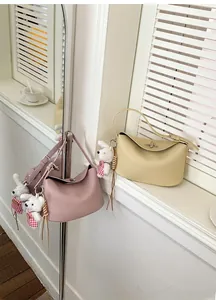 Detailed view of textured leather handbags with metal locks and cute rabbit charm