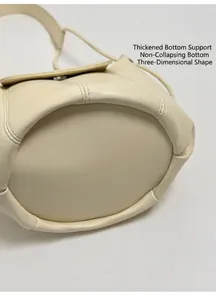 Close-up of the reinforced thick base on the beige bucket bag for a structured shape
