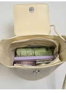 Interior view of cream bucket bag showing large capacity with magnetic flap and zip pocket