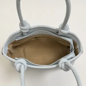 Ice blue minimalist top handle bag showing spacious interior with zipper closure
