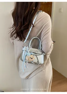 Chic silver metallic mini square bag with cute bear charm and elegant ribbon detail