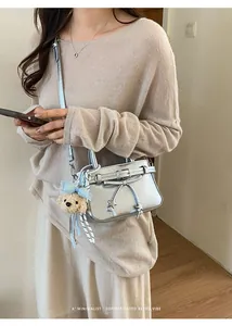 Silver textured crossbody bag with star buckle and cute brown bear plush charm accessory