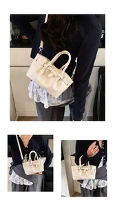 Detail of cream patent leather bucket bag featuring a decorative belt buckle and slim strap