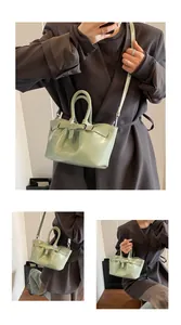 Detail view of mint green patent leather bucket bag with decorative buckle and slim strap