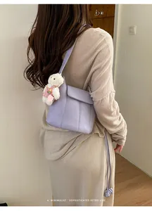 Detail showing lavender leather bucket bag with a cute white plush bear pendant