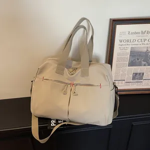 Minimalist beige large capacity canvas travel bag with front zip pockets and shoulder strap