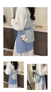 Detail view of light blue lychee pattern bucket bag with a decorative horse charm