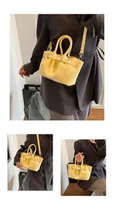 Detailed views of yellow glossy patent leather bucket bag with top handles and strap