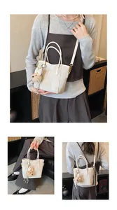 Detail of cream canvas tote featuring fine fabric texture and golden hardware accents