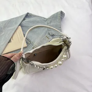 Sac à bandoulière blanc en similicuir avec chaîne à perles et cœurs sur denim bleu