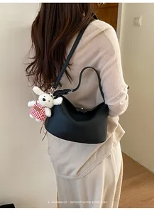 Litchi pattern leather bag with cute puppy pendant detail shown on shoulder