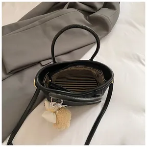Chic black pebble leather tote bag with striped lining and fluffy bow charm