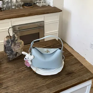 Detail of light blue lychee pattern handbag with cute bear charm and silver turn-lock